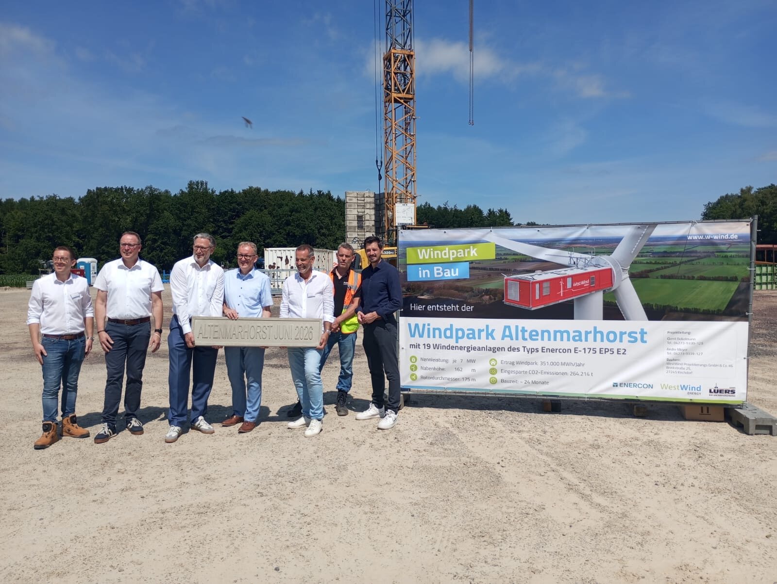 Grundsteinlegung Windpark Altenmarhorst – Gruppenfoto mit Andenken-Stein vor dem Bauschild